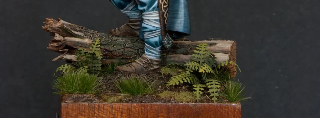 Main image for Minichix Studio article on building woodland scenic miniature base for Viking Chief - featuring wooden log and ferns