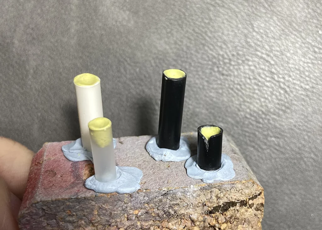 Adding Milliput to the top of the miniature candles to create indentations - step-by-step scenic base tutorial by Minichix Studio
