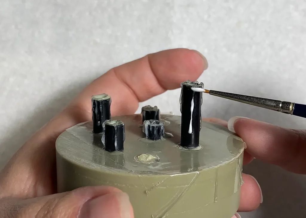 Adding layers of melted wax drips on miniature candle with old brush - step-by-step tutorial by Minichix Studio.