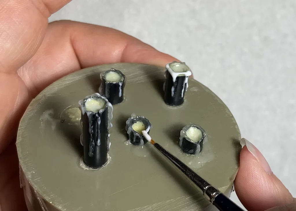Layering additional melted wax drips on miniature candles with old brush - step-by-step tutorial by Minichix Studio.